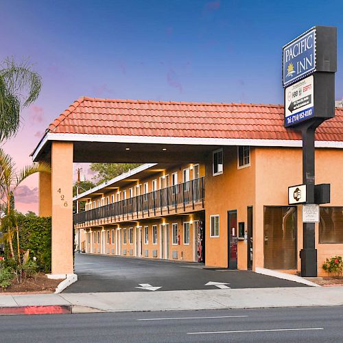 This image shows a two-story hotel with a sign reading 