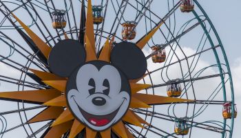 A Ferris wheel featuring a large character face at its center, with riders enjoying the view from the colorful gondolas.