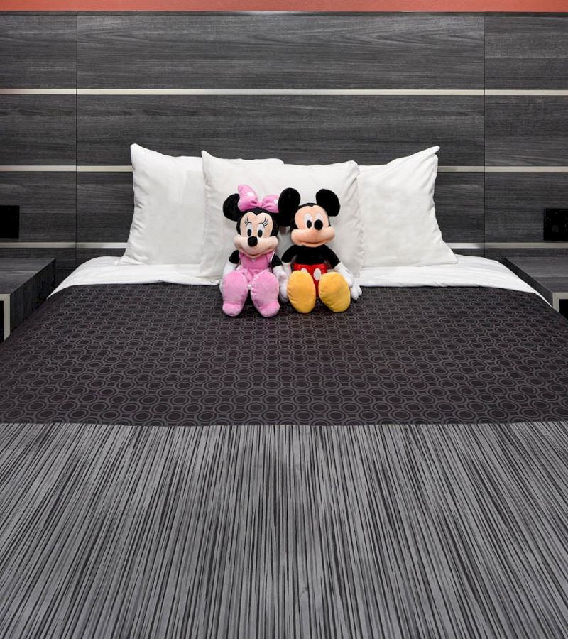 A bed with two stuffed animals sitting on it