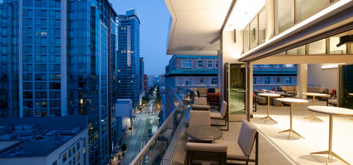 A balcony with seating area overlooking the city