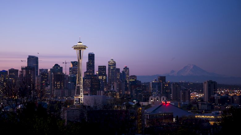 This image shows the Seattle skyline with the iconic Space Needle at dusk, with Mount Rainier visible in the background.
