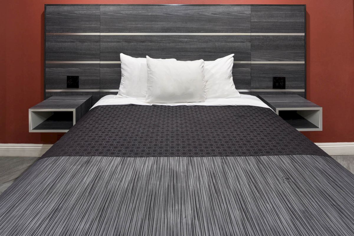 A bed with a dark wood headboard and two small nightstands